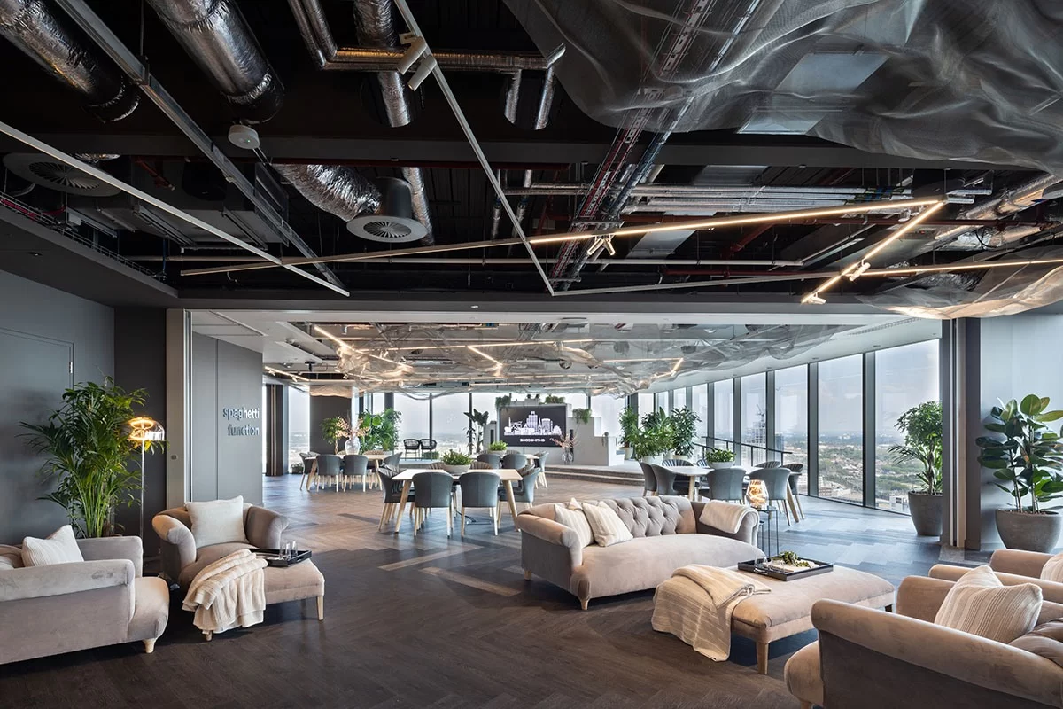 Shoosmith Birmingham lounge area with sofas armchairs and cushion and blankets on them  and windows around showcasing the view